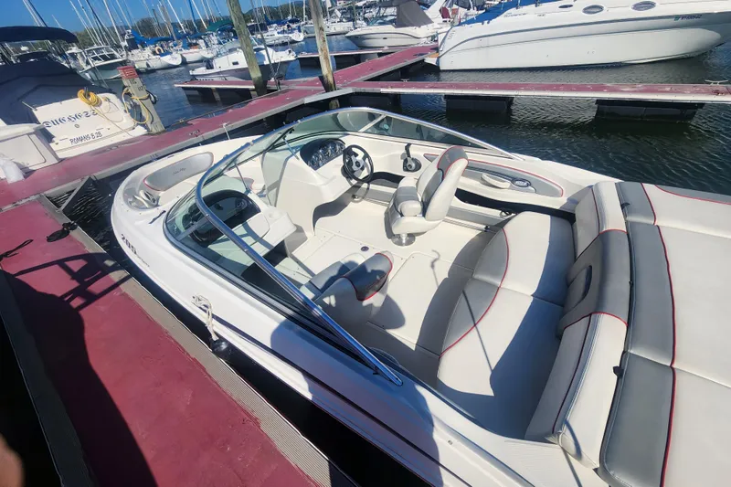 Slide: The Image of 2008 Sea Ray 205 Sport boat docked at marina, featuring sleek white interior. - 16