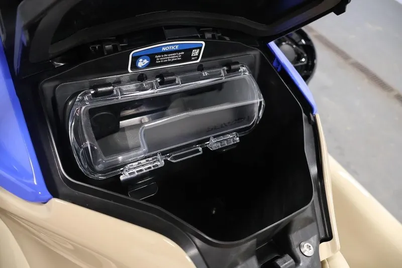 Slide: The Image of 2026 Sea-Doo Wake 170 storage compartment with clear cover and notice label. - 12