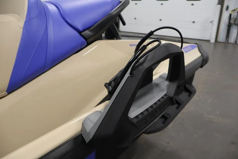 Slide: The Image of 2026 Sea-Doo Wake 170 jet ski with blue seat and beige body in a garage. - 10