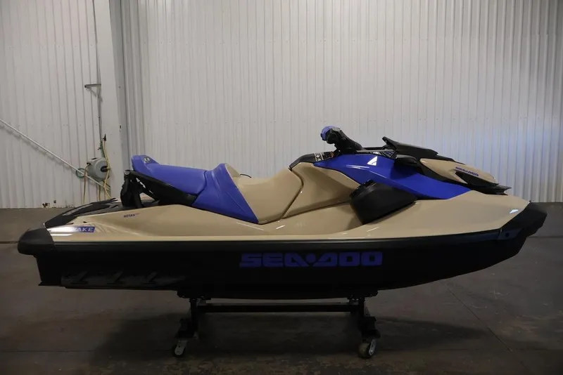 Slide: The Image of 2026 Sea-Doo Wake 170 jet ski in a showroom, featuring a sleek blue and beige design. - 5