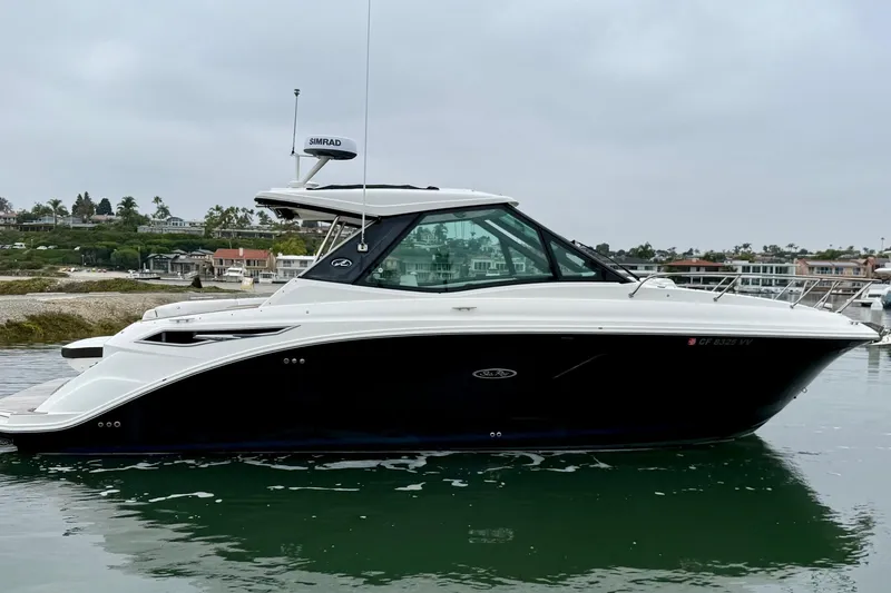 Slide: The Image of 2023 Sea Ray Sundancer 320 Coupe in a serene marina setting. - 1