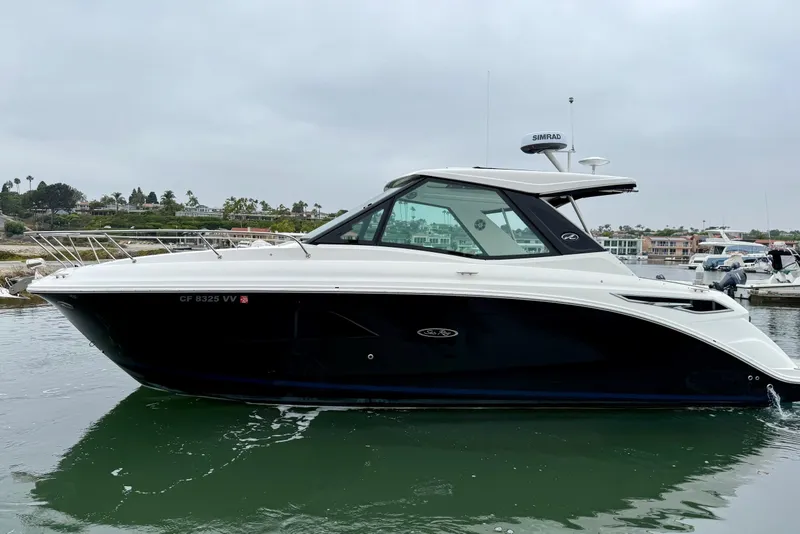 Slide: The Image of 2023 Sea Ray Sundancer 320 Coupe in marina, sleek design, calm waters. - 10