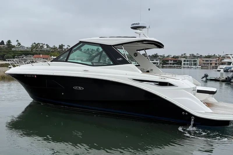 Slide: The Image of 2023 Sea Ray Sundancer 320 Coupe docked in a marina, side view. - 11