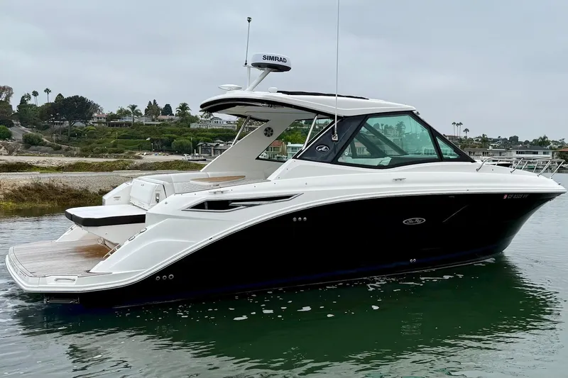 Slide: The Image of 2023 Sea Ray Sundancer 320 Coupe yacht on calm water, showcasing sleek design and luxury features. - 14