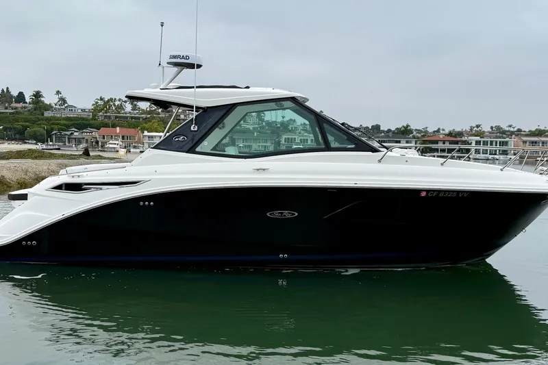 Slide: The Image of 2023 Sea Ray Sundancer 320 Coupe docked by a serene waterfront. - 16