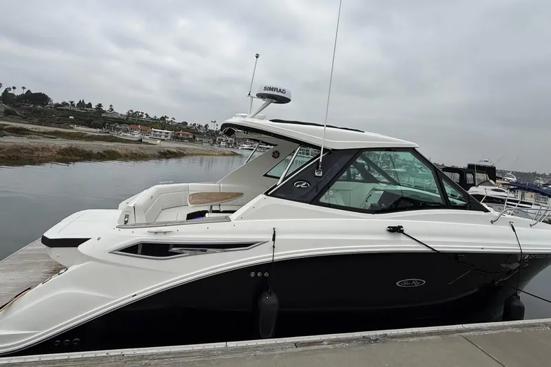 Slide: The Image of 2023 Sea Ray Sundancer 320 Coupe docked at marina, showcasing sleek design and luxury features. - 18