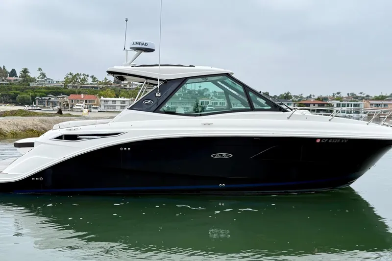 Slide: The Image of 2023 Sea Ray Sundancer 320 Coupe yacht docked in a marina. - 2