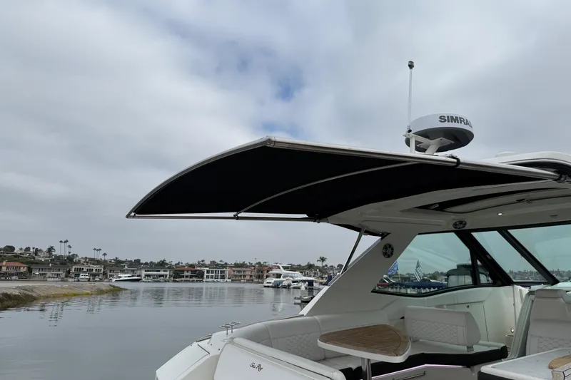 Slide: The Image of 2023 Sea Ray Sundancer 320 Coupe interior with white seating and wood flooring. - 36