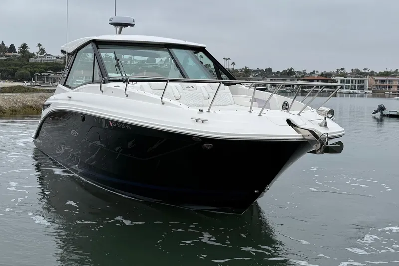 Slide: The Image of 2023 Sea Ray Sundancer 320 Coupe in calm waters, showcasing sleek design and modern features. - 4