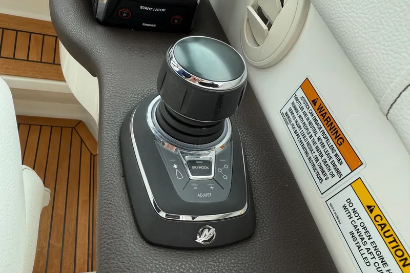 Slide: The Image of 2023 Sea Ray Sundancer 320 Coupe helm with white leather seats and wooden flooring. - 42