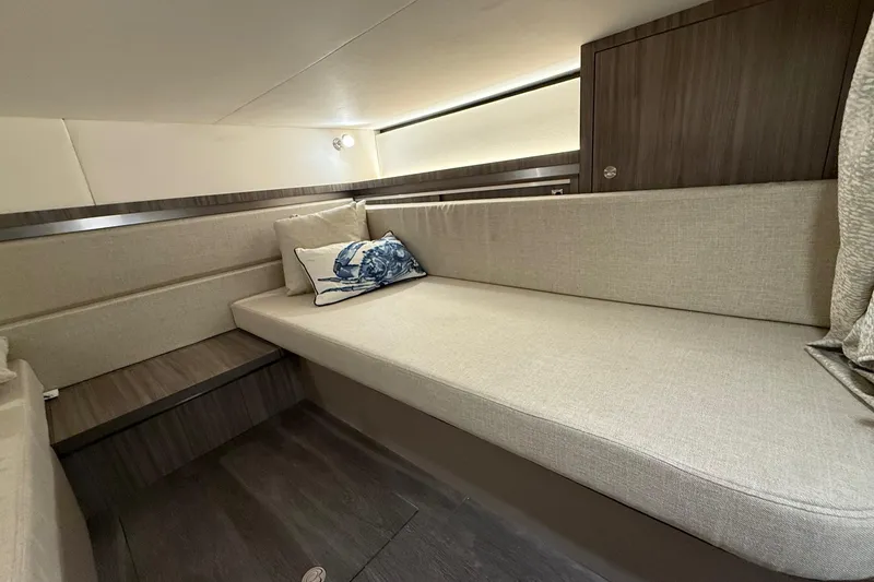 Slide: The Image of Interior of 2023 Sea Ray Sundancer 320 Coupe, featuring elegant beige seating and nautical decor. - 57