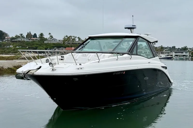 Slide: The Image of 2023 Sea Ray Sundancer 320 Coupe cruising on calm waters, showcasing sleek design and luxury. - 6
