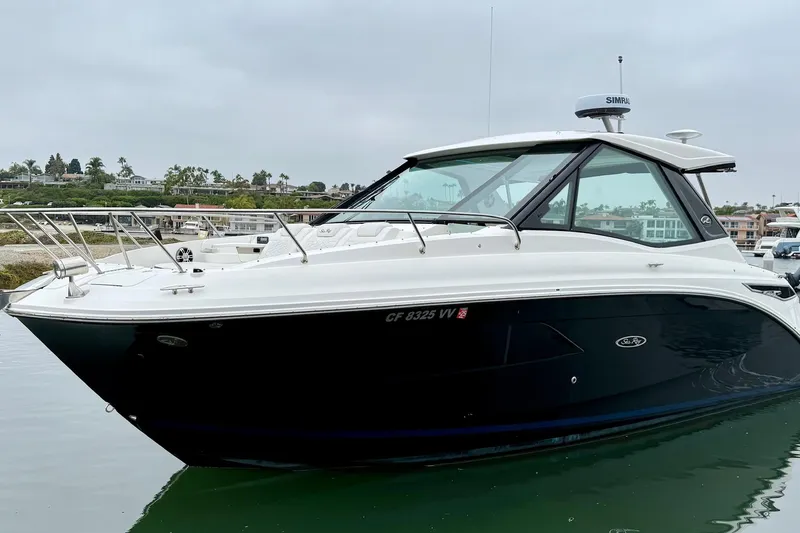 Slide: The Image of 2023 Sea Ray Sundancer 320 Coupe yacht on calm water, showcasing sleek design. - 8