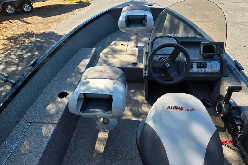 Slide: The Image of 2018 Alumacraft Escape 165 CS boat interior with steering wheel and seating. - 10