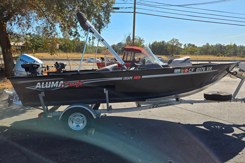 Slide: The Image of 2018 Alumacraft Escape 165 CS boat on trailer, parked outdoors. - 8