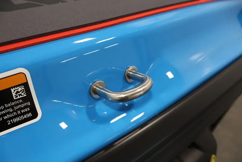 Slide: The Image of 2026 Sea-Doo RXP-X 325, blue hull detail with metal handle and safety sticker. - 25