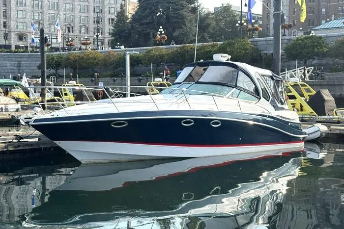The Image of 2014 Four Winns V375 boat docked in a marina with urban backdrop. - 0