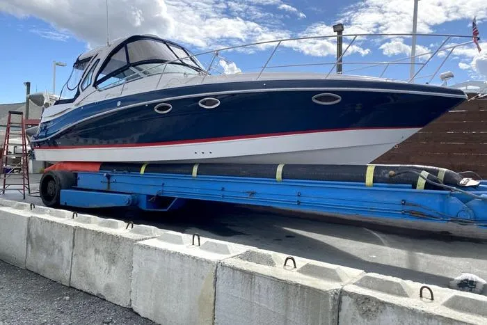 Slide: The Image of 2014 Four Winns V375 boat on trailer, blue and white design, docked outdoors. - 18