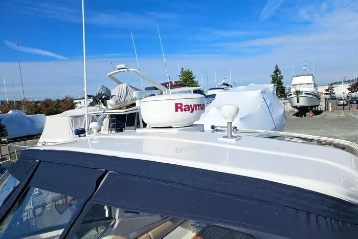 Slide: The Image of 2014 Four Winns V375 boat with Raymarine radar, docked in a marina under clear blue skies. - 21