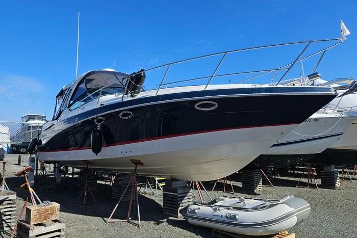 Slide: The Image of 2014 Four Winns V375 boat on stands, blue hull, clear sky background. - 29