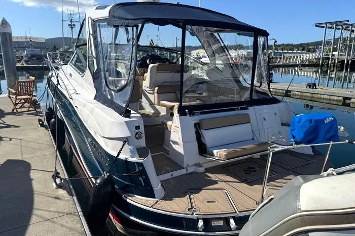 Slide: The Image of 2014 Four Winns V375 boat docked at marina, featuring spacious seating and clear canopy. - 3