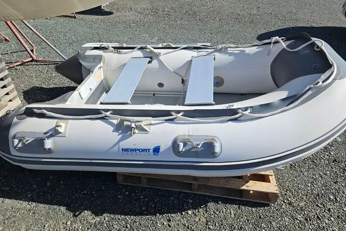Slide: The Image of Inflatable Newport dinghy on wooden pallet, outdoor setting, 2014 Four Winns V375. - 32
