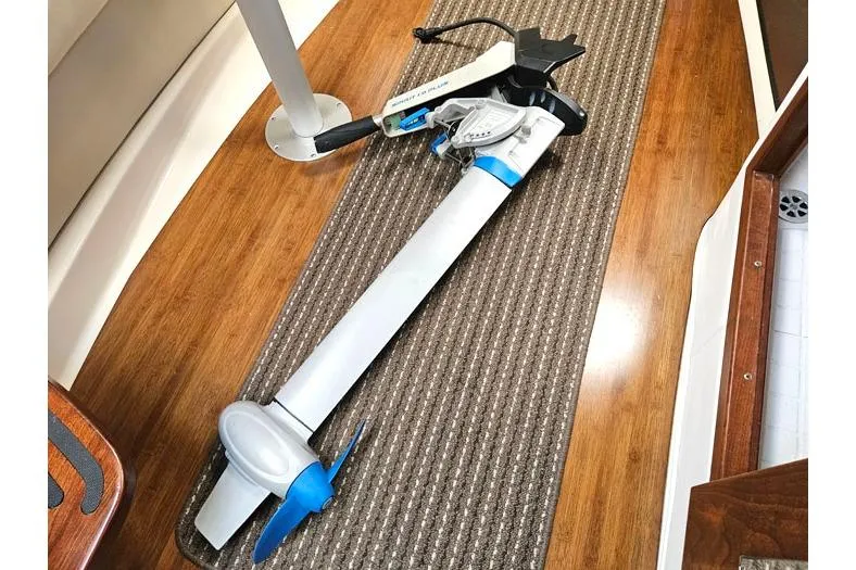 Slide: The Image of 2014 Four Winns V375 interior with a folded electric outboard motor on carpeted floor. - 34