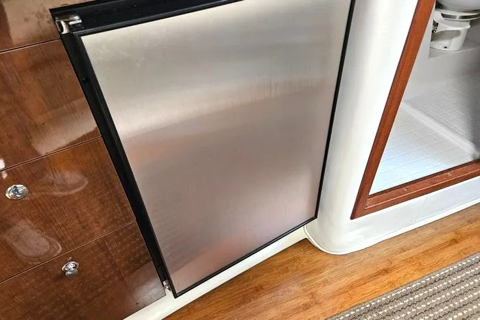 Slide: The Image of 2014 Four Winns V375 yacht interior with stainless steel fridge and wooden flooring. - 9