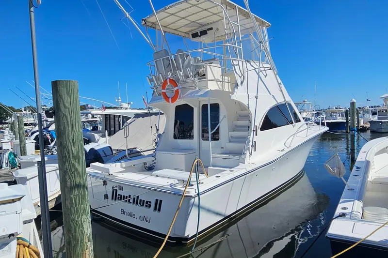 The Image of 2004 Luhrs 34 Convertible yacht docked at marina, featuring flybridge and sleek design. - 0