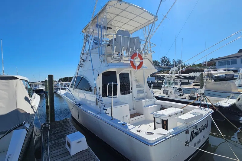 Slide: The Image of 2004 Luhrs 34 Convertible yacht docked at marina under clear blue sky. - 1