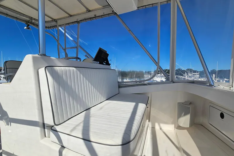 Slide: The Image of 2004 Luhrs 34 Convertible boat interior with cushioned seating and clear windows. - 21