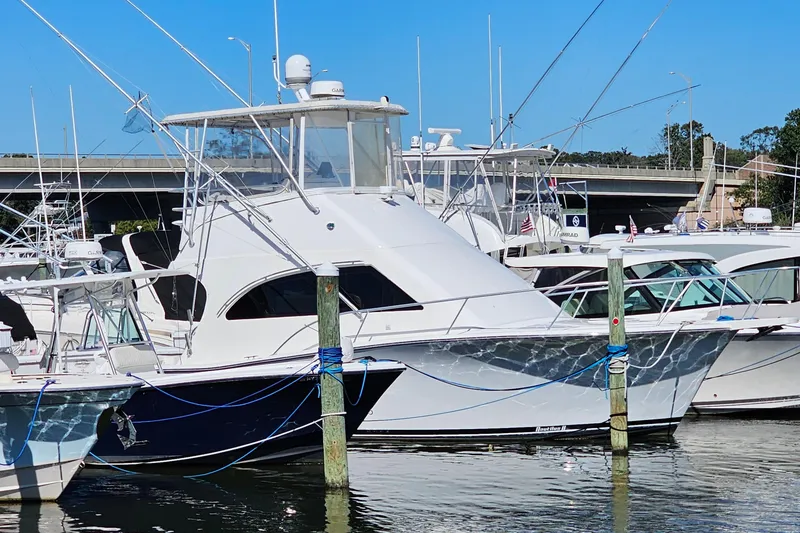 Slide: The Image of 2004 Luhrs 34 Convertible yacht docked at marina, clear blue sky background. - 3