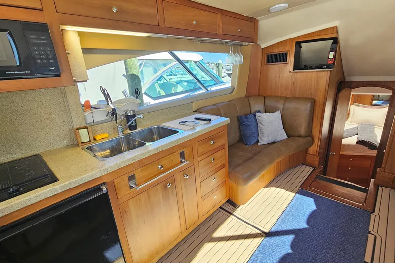 Slide: The Image of 2004 Luhrs 34 Convertible yacht interior with kitchen, seating, and cozy cabin. - 30