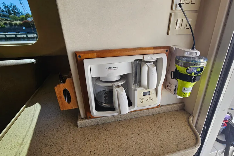 Slide: The Image of 2004 Luhrs 34 Convertible interior with mounted coffee maker and emergency equipment. - 35