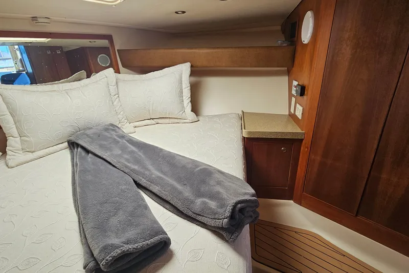 Slide: The Image of Cozy cabin interior of 2004 Luhrs 34 Convertible with plush bedding and wooden cabinetry. - 41