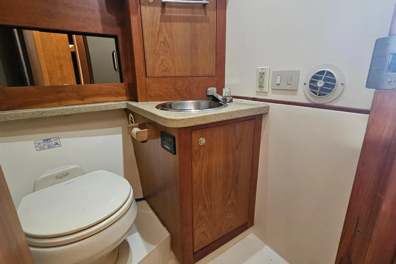 Slide: The Image of 2004 Luhrs 34 Convertible yacht bathroom with wooden cabinetry and compact fixtures. - 42