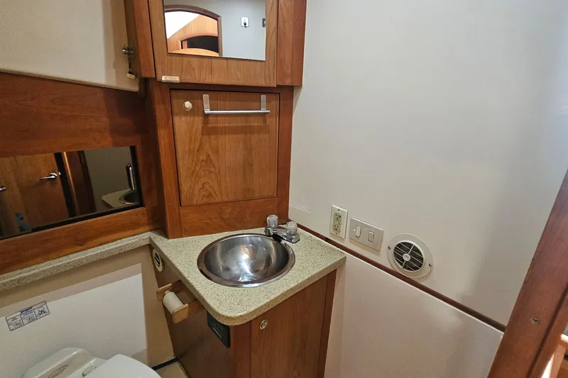 Slide: The Image of 2004 Luhrs 34 Convertible yacht bathroom with wooden cabinetry and stainless steel sink. - 43