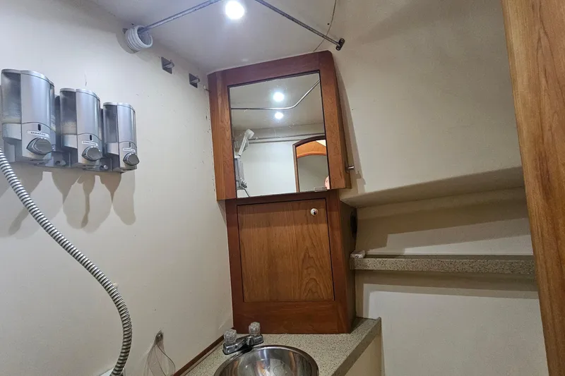 Slide: The Image of 2004 Luhrs 34 Convertible bathroom with dispensers, mirror, and sink. - 44
