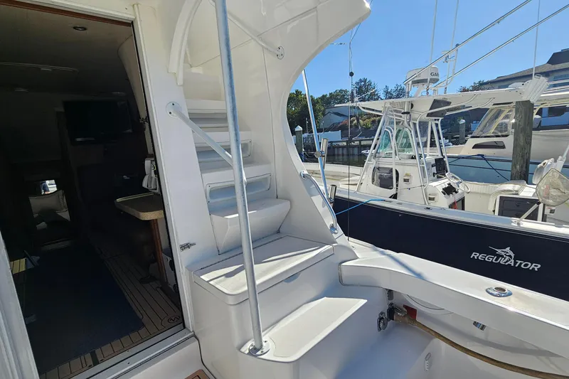 Slide: The Image of 2004 Luhrs 34 Convertible yacht interior with stairs and docked boats in marina. - 5