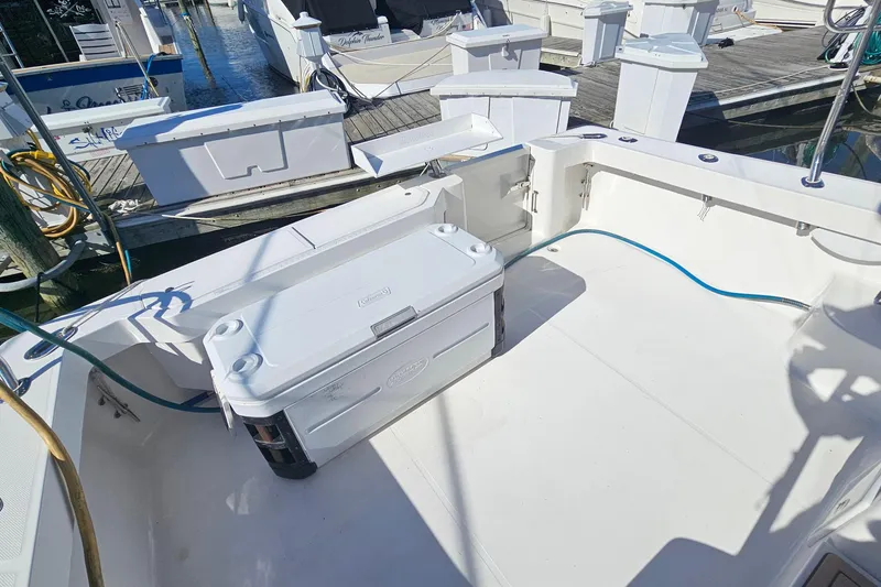 Slide: The Image of 2004 Luhrs 34 Convertible boat deck with storage and cooler, docked at marina. - 8