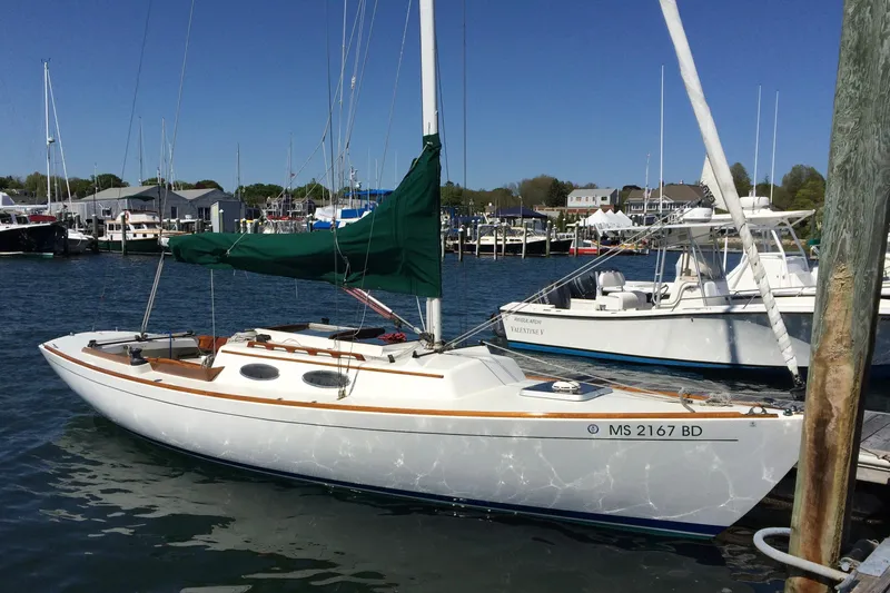 The Image of 1995 Alerion Express 28 sailboat docked in a marina with green sail cover. - 0