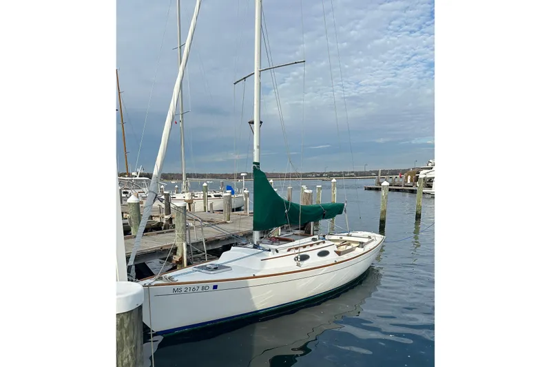 Slide: The Image of 1995 Alerion Express 28 sailboat docked at a marina under a cloudy sky. - 2