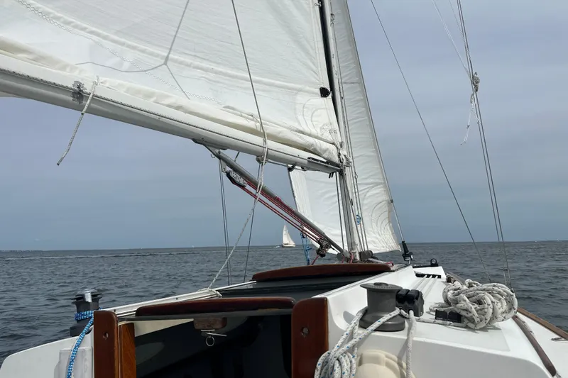 Slide: The Image of Sailing on a 1995 Alerion Express 28 with white sails over open water. - 8