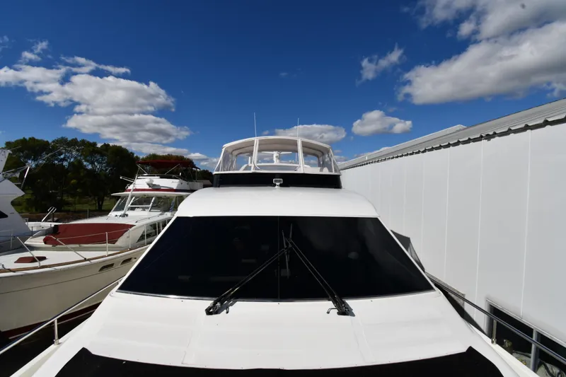 Slide: The Image of 2001 Ferretti Yachts 72 docked under a clear blue sky with clouds. - 16