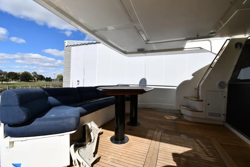 Slide: The Image of Outdoor seating area on a 2001 Ferretti Yachts 72, featuring wooden deck and blue cushions. - 22