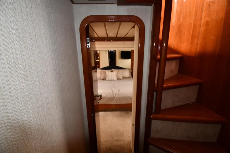 Slide: The Image of Interior view of 2001 Ferretti Yachts 72, featuring a cozy bedroom and wooden staircase. - 69