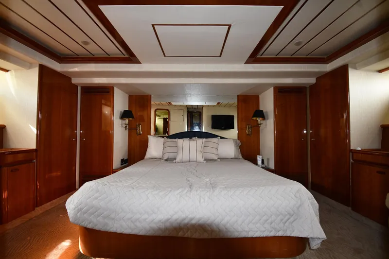 Slide: The Image of Luxurious bedroom interior on 2001 Ferretti Yachts 72, featuring elegant wood paneling and cozy bedding. - 70