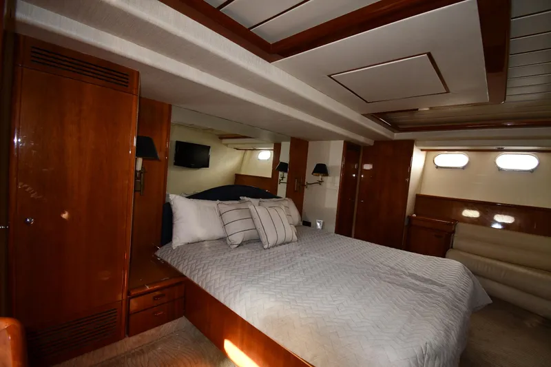 Slide: The Image of Luxurious bedroom interior of 2001 Ferretti Yachts 72 with wood paneling and cozy bedding. - 74