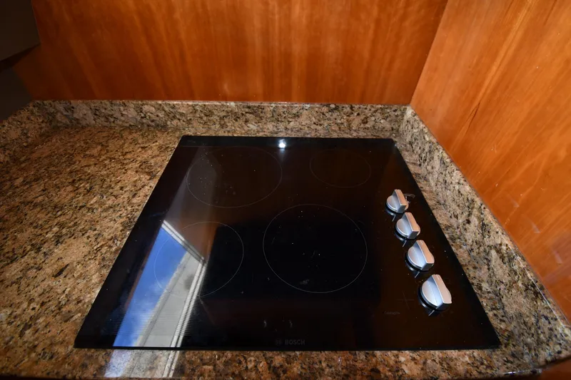 Slide: The Image of Granite countertop with a Bosch electric cooktop on a 2001 Ferretti Yachts 72. - 92