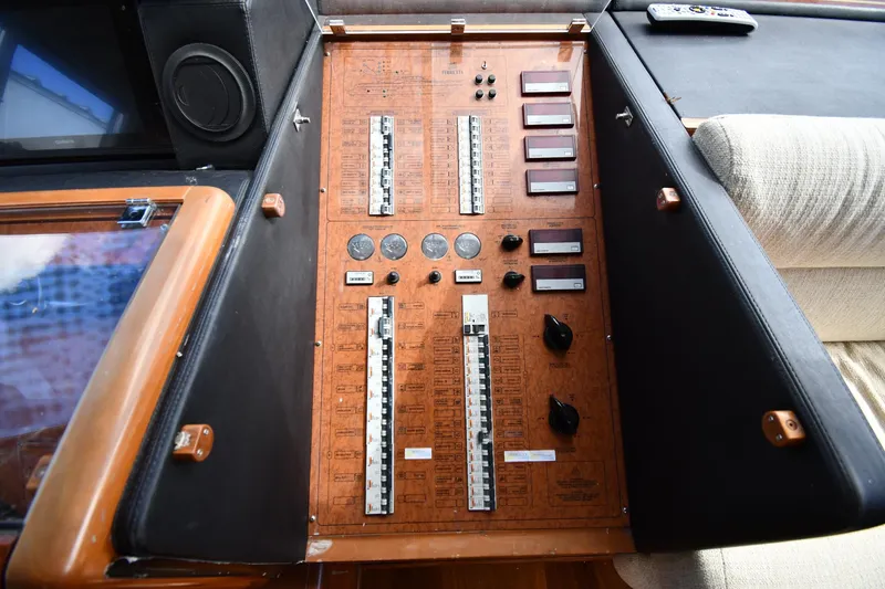 Slide: The Image of Control panel of a 2001 Ferretti Yachts 72, featuring switches and gauges. - 99